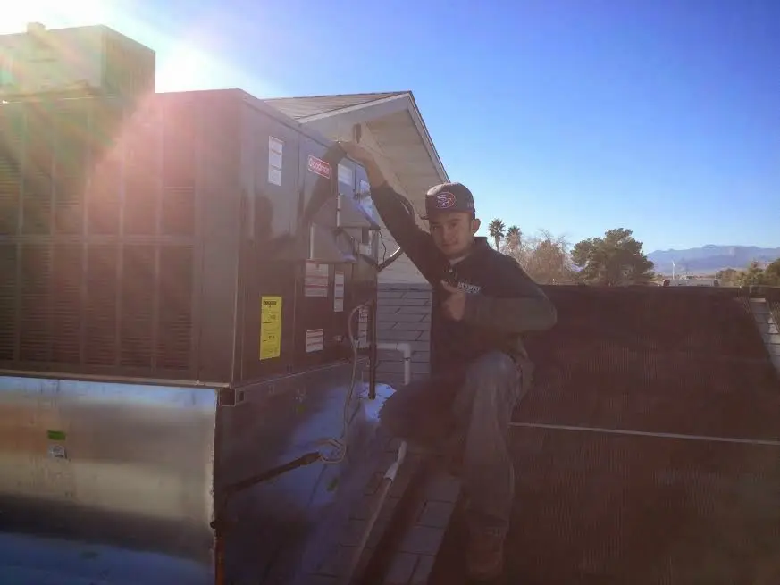 HVAC technician performing AC Tune-Up on a rooftop unit in Kings Grant